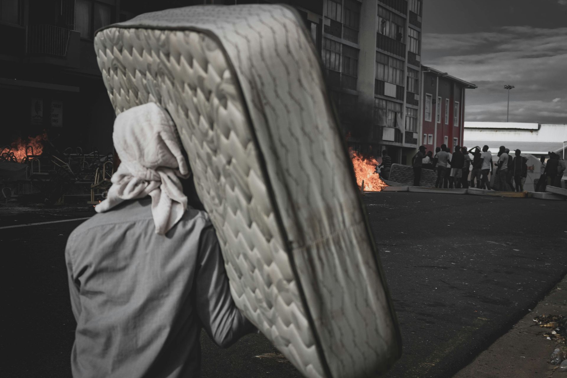 person carrying white mattress